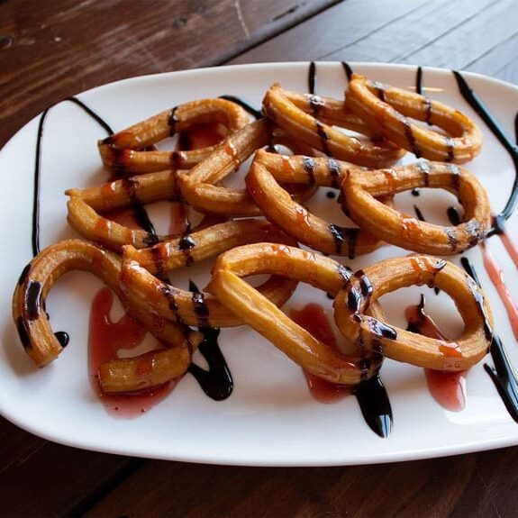 Spurgytės churros su šokolado ir braškių sirupu