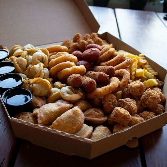 Užkandžių rinkinys, sudarytas iš koldūnų, sūrio kepsnelių, fri bulvyčių, svogūnų žiedų